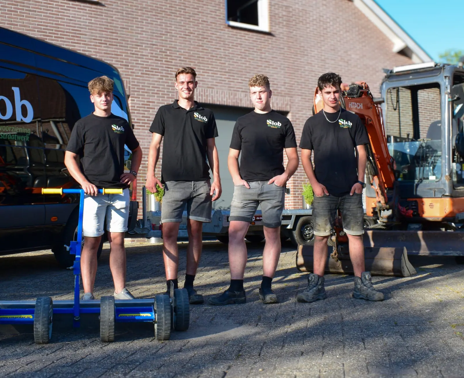 Het team van Slob Tuinen bij de bedrijfsbus en kraan